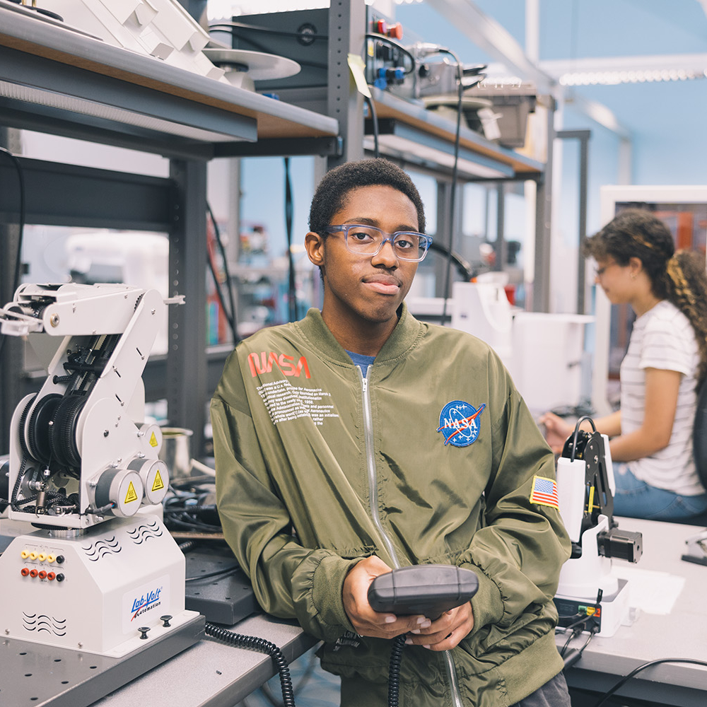 African american male wearing NASA sweatshirt learning in an engineering lab.