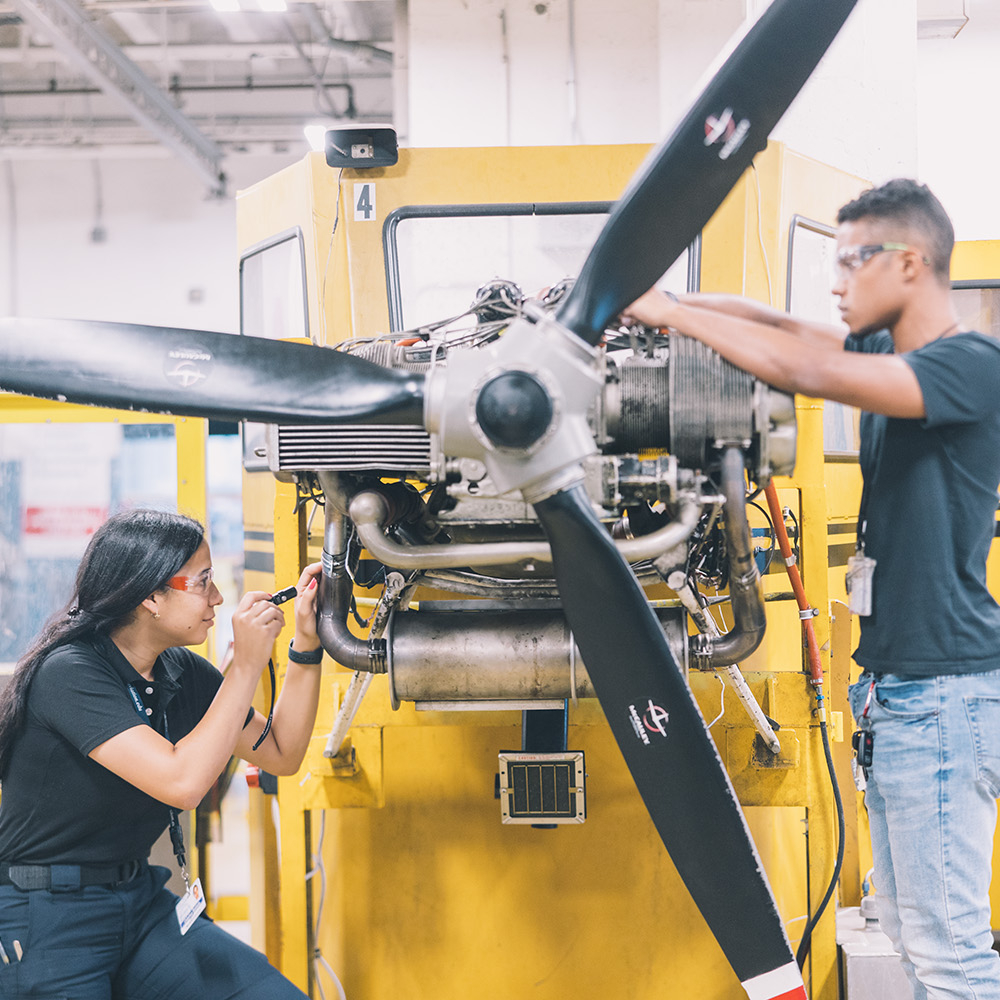 Diverse students work on plane engine during their Transportation, distribution, and logistics CTE program