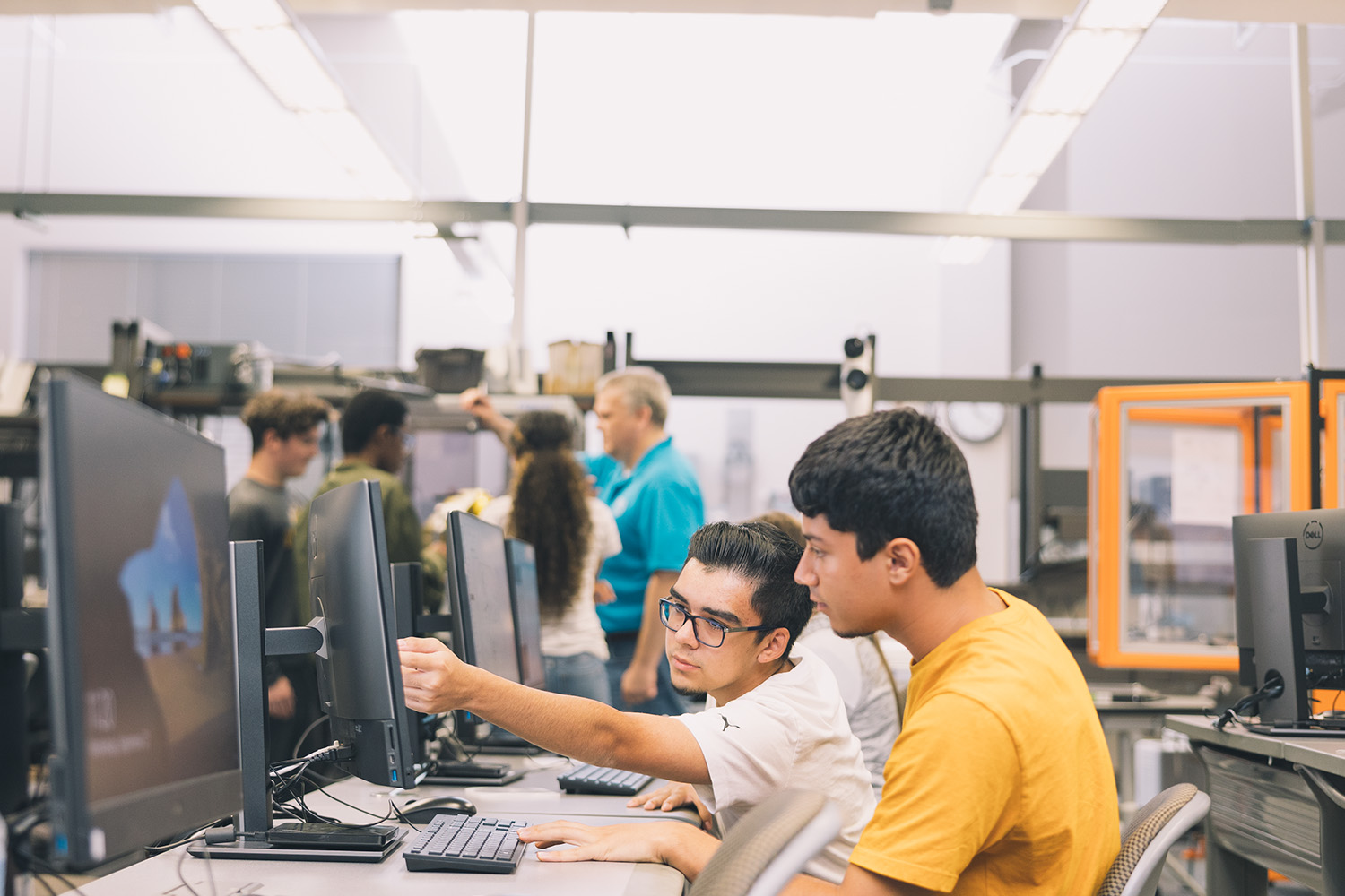 Two male IT students working together to solve an issue.