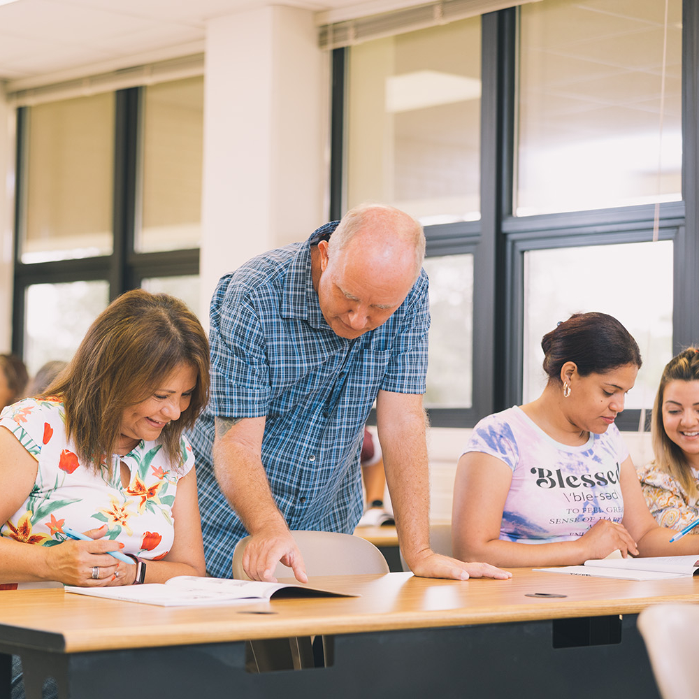 Teacher in Adult Education class helping students