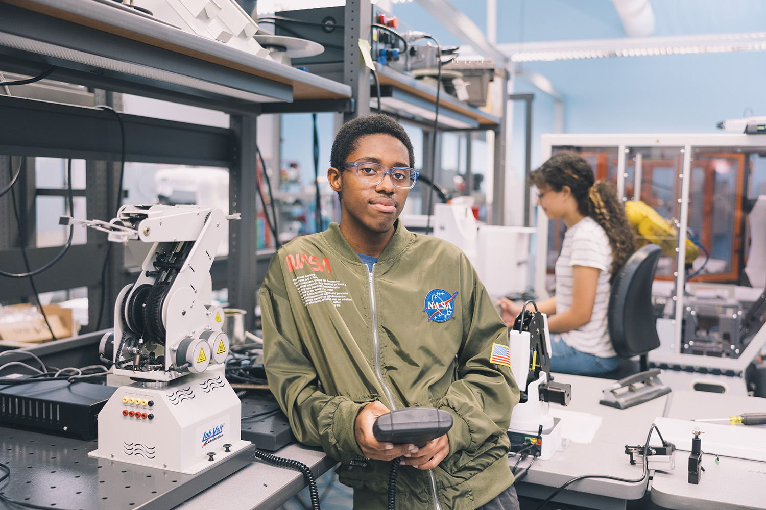 African american male wearing NASA sweatshirt learning in an engineering lab.