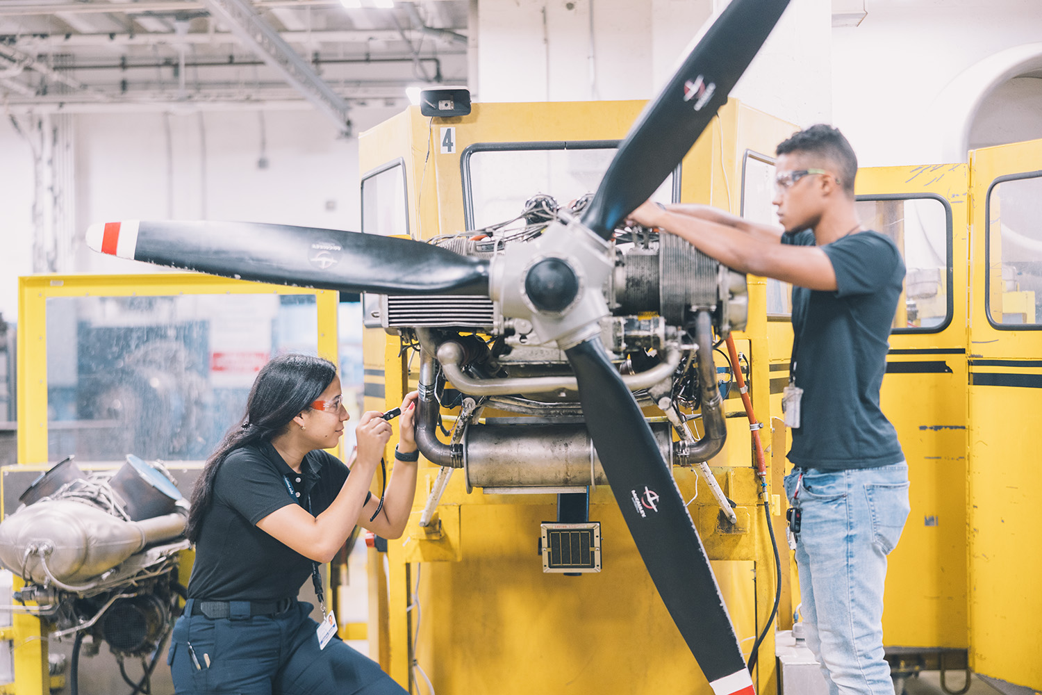 Diverse students work on plane engine during their Transportation, distribution, and logistics CTE program